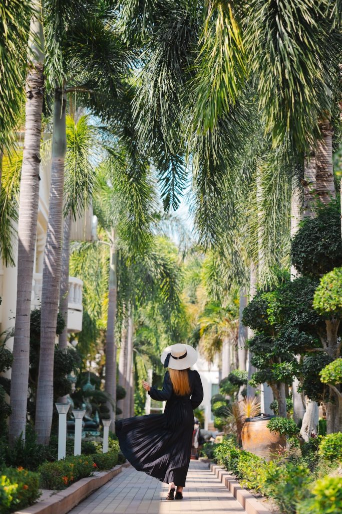 Woman walking through the lush tropical garden at Thai Garden Resort Pattaya.