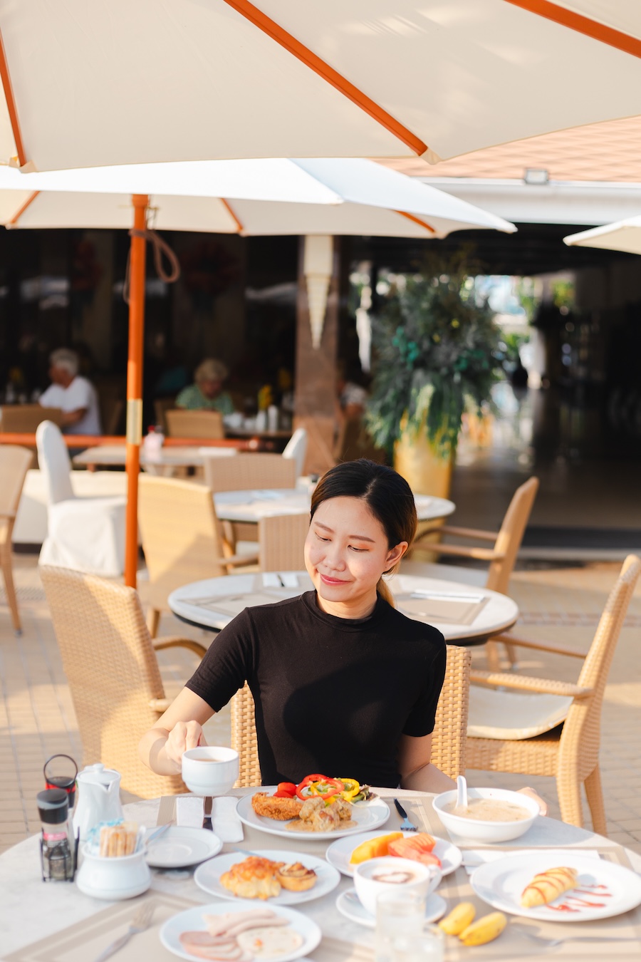 Woman enjoying breakfast at Thai Garden Oasis restaurant, Thai Garden Resort Pattaya.