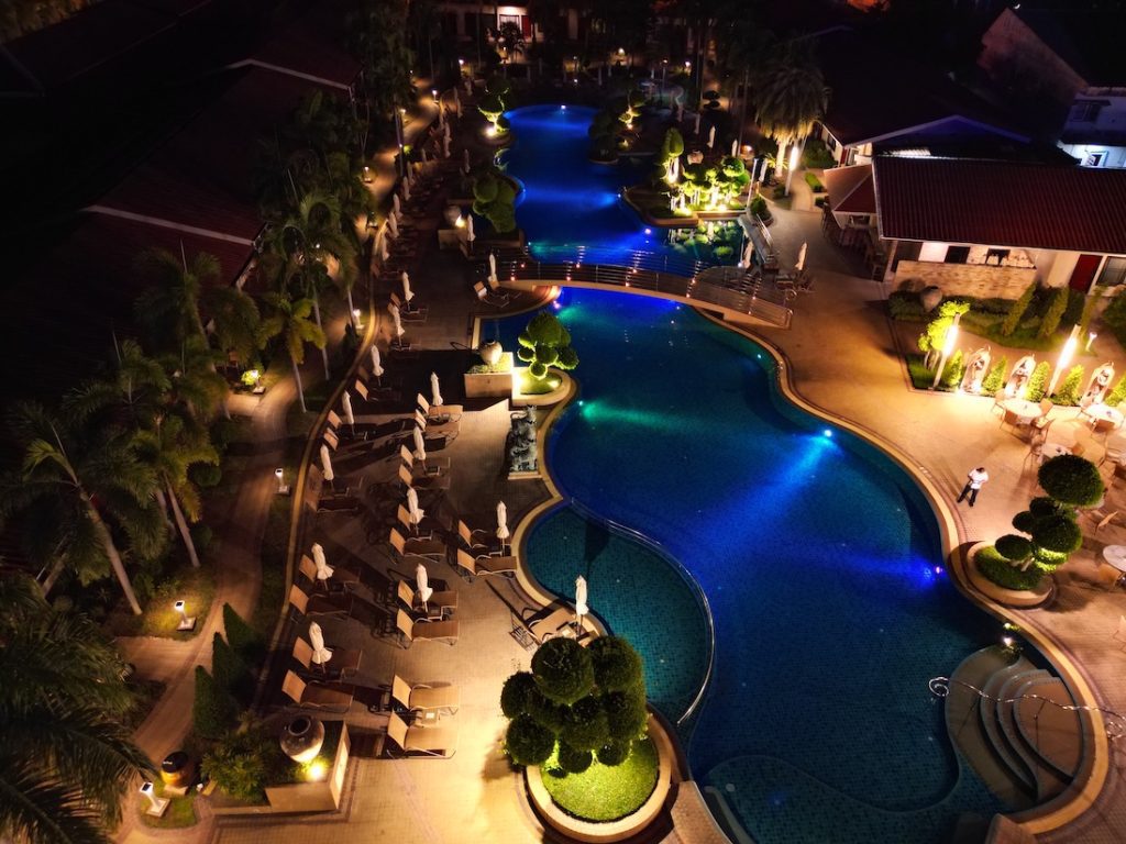 Night view of the Thai Garden Resort Pattaya swimming pool illuminated with ambient lights and surrounded by tropical gardens.